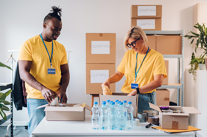 These examples highlight people working together to pack food, water, clothing, and other...